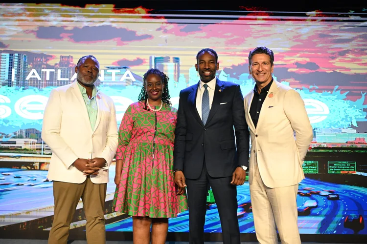 EO Atlanta leaders with Mayor Andre Dickens in front of an Atlanta skyline backdrop